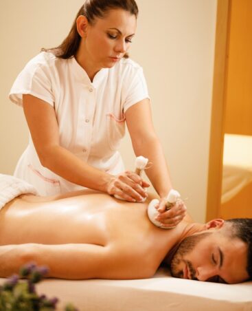 female-therapists-massaging-back-man-with-thai-herbal-compress-health-spa (1)